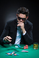 Gambling and Casino Concepts. Caucasian Young Handsome Pocker Player Staking and Betting To Win At Pocker Table With Chips And Cards