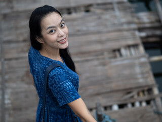 Fototapeta premium Young beautiful asian woman at Auttamanusorn Wooden Bridge (Sapan Mon) Kanchanaburi , Thailand when she have holiday vacation
