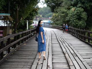 Young beautiful asian woman at Auttamanusorn Wooden Bridge (Sapan Mon) Kanchanaburi , Thailand when she have holiday vacation