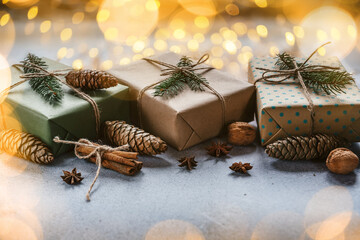 Christmas zero waste packaging gift boxes with pine cones, wooden eco decor and Christmas lights