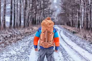 man traveler with a backpack in the forest, winter view in the american forest, north america...