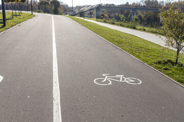 White road markings for pedestrians and cyclists.The walking and cycling paths in the park are...