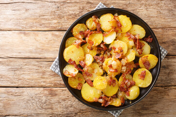 German Pan Fried Potatoes or Bratkartoffeln With Bacon and Onion close up in the plate on the...