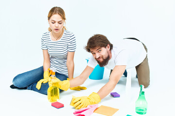 Man and woman near the sofa detergent rags sponges protective gloves