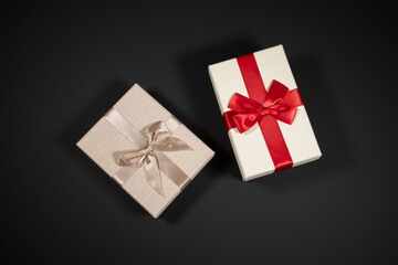 Wrapped vintage gift boxes with red ribbon bow, isolated on black