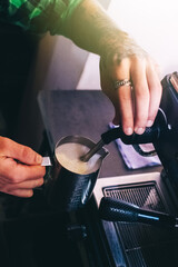 Close-up of a barista preparing coffee. The process of making cappuccino in a coffee machine. Measuring cup in hand. The hot drink is poured into a paper cup. Takeaway food