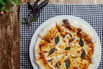Close-up of Margarita pizza in a disposable dish. Top view of takeaway food in a fast food cafe. On photo - mozzarella cheese, tomatoes, and red basil. The classic recipe. Food for family and friends.