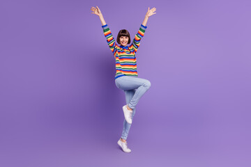 Photo of lovely lady dance raise hands wear striped sweater jeans shoes isolated purple color...