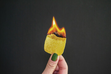 the girl holds burning chips. flame in a woman's hand. burning harmful and extra calories