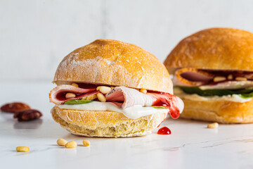 Thanksgiving sandwich with turkey, nuts and cranberries, white background.