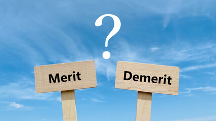 MeritとDemeritの文字入りの2つのプレートとクエスチョンマークと青空
