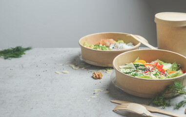 Healthy lunch in eco-friendly packaging with wooden cutlery. Plastic free take away food on grey...