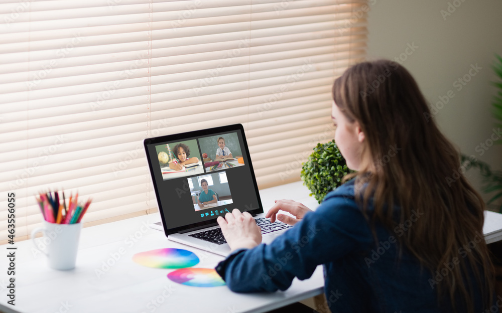 Poster Caucasian girl using laptop for video call, with smiling diverse elementary school pupils on screen