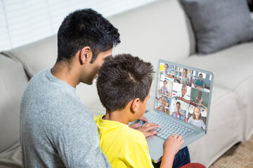 Obraz premium Biracial boy with father using laptop for video call, with elementary school pupils on screen