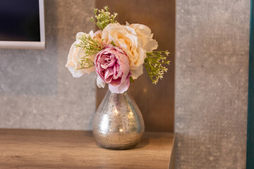 Flowers in the vase on wooden table in a hotel room