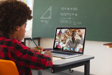African american boy using laptop for video call, with diverse high school pupils on screen