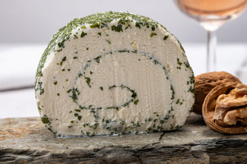 Cheese collection, fresh white soft goat French cheese roll with aromatic herbs and chives