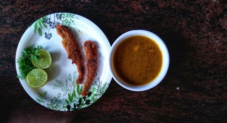 Fried Bombay duck fish or bombil in a plate with Lemon and coriander, famous food of Mumbai and coastal area of maharashta, India.