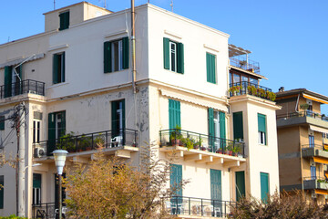 Fototapeta na wymiar Old town architecture, Corfu. Medieval buildings in Greece island. Photo of local apartment building on streets in Corfu, Kerkyra. Windows with shutters. Facades of old houses. Traveling concept.