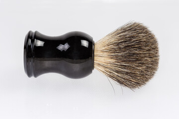 Shaving brush lies on light surface, top view close-up