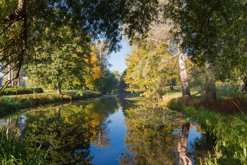 Water canal in the autumn park at sunny morning