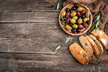 Virgin olive oil, olives and fresh bread on the table. Top view
