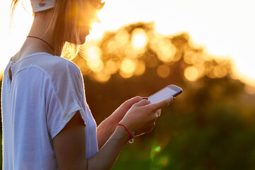 Female using modern smartphone outdoors.