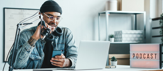 Mixed race man with stubble streaming his audio podcast at cozy home broadcast studio