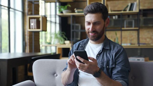 Happy young caucasian business man freelancer using mobile phone device