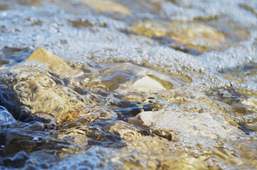 the wave breaks on the stones