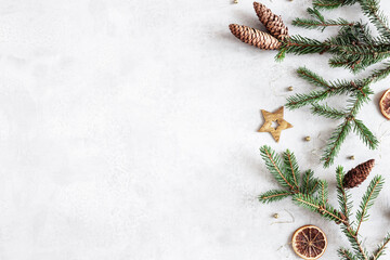 Christmas composition. Fir tree branches, christmas golden decorations on gray background. Flat lay, top view, copy space