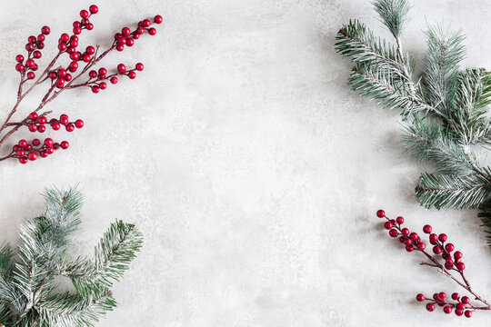 Christmas composition. Fir tree branches, red berries on gray background. Christmas, winter, new year concept. Flat lay, top view, copy space