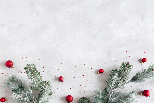 Christmas composition. Fir tree branches, red decorations on gray background. Christmas, winter, new year concept. Flat lay, top view, copy space