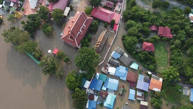 Flood waters overtake a house and rice field at Central of Thailand in 2021. Many buildings are submerged in water. 4K disaster from above view by drone