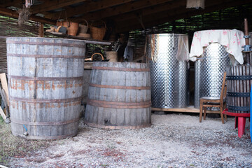 Old wine barrels in cellar. Large containers made from metal and wood and various sizes for initial...