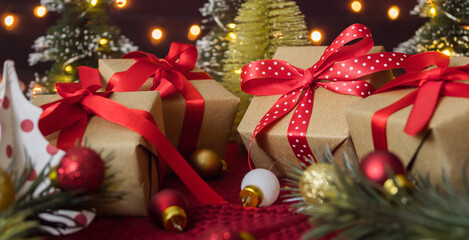 Christmas background with gift boxes, balls and fir tree against bokeh lights.