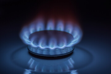 Kitchen gas stove burner with blue flame, natural gas market concept.