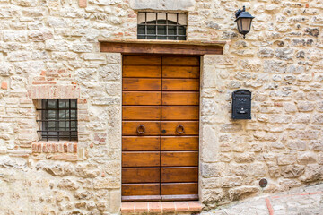 Fototapeta na wymiar Vintage front door in the medieval city of Italy. Ancient wooden gate. Old city streets, beautiful doors and unusual door handles.