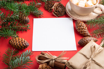 Christmas or New Year frame composition. Decorations, cones, fir and spruce branches, cup of coffee, on a red background. Side view, copy space.