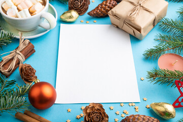 Christmas or New Year composition, template. Decorations, cones, fir and spruce branches, cup of coffee, on a blue background. Side view, copy space.