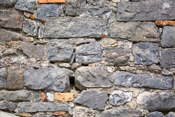Stone antique old wall as a background or texture. Vintage background of a fortress wall in loft and grunge style with place for text and copy space.