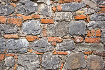 Stone antique old wall as a background or texture. Vintage background of a fortress wall in loft and grunge style with place for text and copy space.
