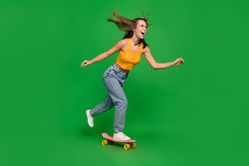 Full body photo of millennial funny brunette lady go wear top jeans shoes isolated on green...