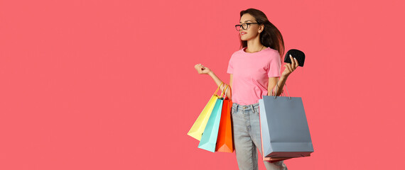 Attractive girl with multicolored paper bags on pink background