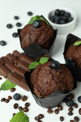 Concept of delicious food with chocolate muffins on white background