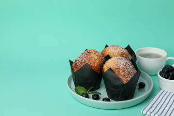 Concept of delicious food with chocolate muffins on mint background