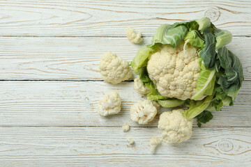Fresh juicy cauliflower with slices on wooden background