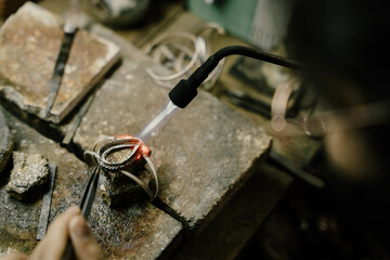 Jeweler at work in jewelry. Desktop for craft jewelry making with professional tools. Close up view of tools. Silver jewelry.