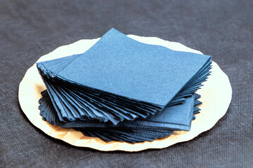 tray with blue paper napkins elegantly arranged on a dark grey tablecloth