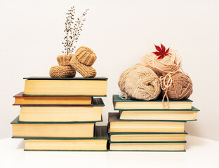 knitting and baby booties on a stack of books
